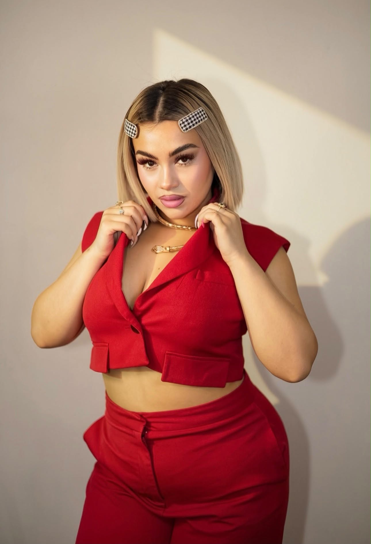 Gem, lash artist and educator, wearing a red suit